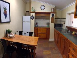 a kitchen with a table and a white refrigerator at Greenock's Old Telegraph Station in Greenock