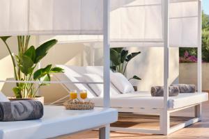 a living room with white furniture and plants at Aparthotel Duva & Spa in Port de Pollensa