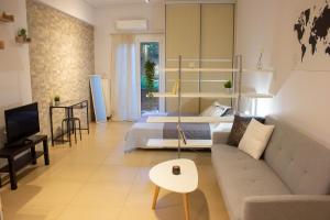 a living room with a couch and a bed at Cozy Studio in Central Glyfada in Athens
