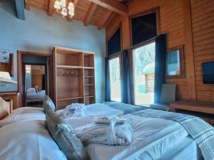 una camera da letto con un grande letto in una camera in legno di La Tresenda Hotel and Mountain Farm a Livigno