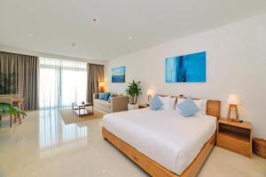 - une chambre avec un grand lit et un salon dans l'établissement Oasis Villa, à Đà Nẵng