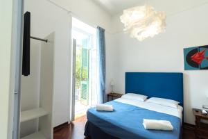 ein Schlafzimmer mit einem blauen Bett und einem großen Fenster in der Unterkunft Areamare in Neapel