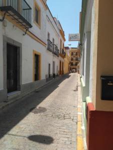 een lege straat in een steegje tussen gebouwen bij Loft céntrico y confortable in Jerez de la Frontera