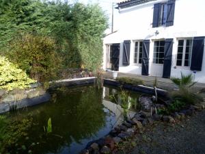 a house and a pond in front of a house at Mas des Vignes Piscine chauffée in Le Champ-Saint-Père
