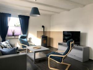 ein Wohnzimmer mit einem Sofa, Stühlen und einem TV in der Unterkunft Ferienhaus Isaro in Ludwigsburg