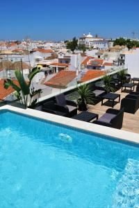 a swimming pool on the roof of a building at Authentic Tavira Hotel in Tavira