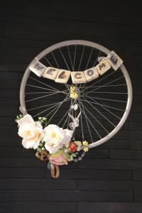 a bicycle wheel with flowers attached to a wall at DP Art Residence - self check in in Kaunas