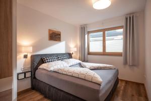 a bedroom with a bed and a window at Apart Alpenrose in Schwendau