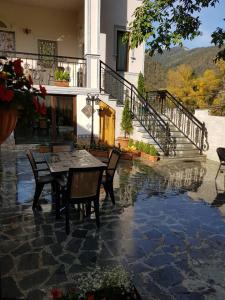 a patio with a table and chairs in front of a house at Borjomi Classic Hotel in Borjomi