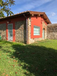 uma casa de tijolos vermelhos com um jardim verde em Stone House 15th Century em Vicchio