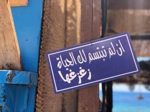 a sign is attached to a wooden fence at Salerno Dormitory in Dahab