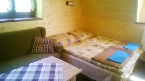 um pequeno quarto com uma cama e um sofá em Chata Ivan em Demanovska Dolina