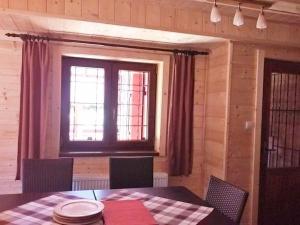 uma sala de jantar com uma mesa e uma janela em Chata Ivan em Demanovska Dolina