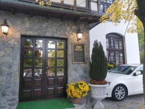 un coche blanco estacionado frente a un edificio con una puerta en Hotel boutique Vila LaKastel en Sinaia