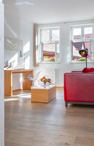 ein Wohnzimmer mit einem roten Sofa und zwei Fenstern in der Unterkunft hezelhof hotel in Dinkelsbühl + 30 Fotos
