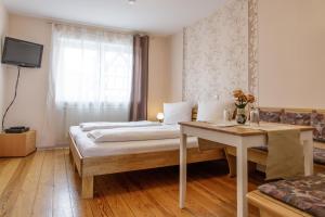 a bedroom with a bed and a table and a window at SchlafGut Gmelin in Angelbachtal