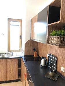 eine Küche mit einer schwarzen Arbeitsplatte und einem Waschbecken in der Unterkunft Newly refurbished spacious and cosy apartment St. John in Bansko