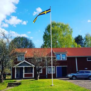 una bandera en un poste delante de una casa en B&B Parkgården Leksand, en Leksand