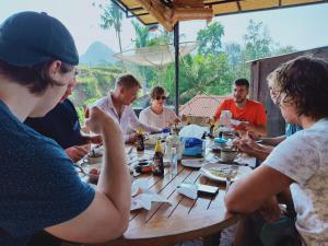 a group of people sitting around a wooden table at Sekumpul BnB in Singaraja
