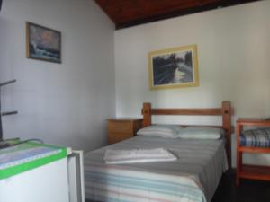 a small bedroom with a bed and a table at Pousada Estrela Matutina in Pirenópolis
