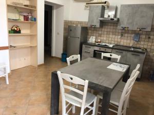 - une cuisine avec une table et des chaises dans la chambre dans l'établissement Casa Certosina, à Alghero