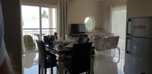 uma sala de jantar com uma mesa e cadeiras e um frigorífico em Northern Pearl Luxury Apartments em Mont Choisy