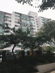 a large building with trees in front of it at Sam Apartment in Goyang