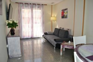 salon z kanapą i oknem w obiekcie Sant Pere 139 Apartments w mieście El Campello