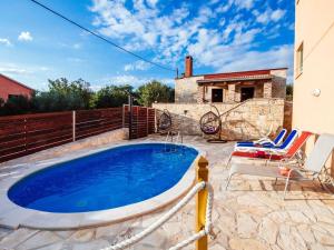 uma piscina num quintal com cadeiras e uma casa em Splendid Holiday Home in Jasenice em Maslenica