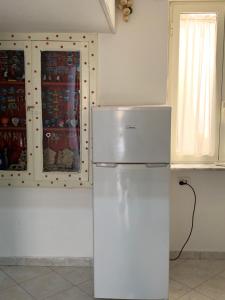 a kitchen with a white refrigerator in a room at DEA PARTHENOPE in Naples