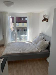 1-Zi. Apartment, Echterdingen bei Flughafen/Messe Stgt. في لاينفيلدن-إشتردينغن: سرير في غرفة نوم مع نافذة كبيرة