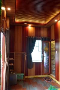 Cette chambre est dotée de murs en bois et d'une fenêtre avec un rideau. dans l'établissement Hà Tiên Homestay, à Hà Tiên