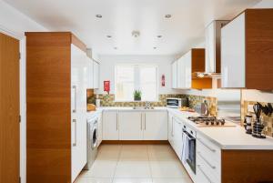 a kitchen with white cabinets and a sink at Listers Lodge in Halifax