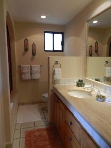 a bathroom with a sink and a toilet and a mirror at Condominios La Tortuga - Ocean Front in Cabo San Lucas