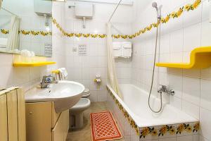 a bathroom with a sink and a tub and a toilet at Villa Marina Apartments in Diano Marina