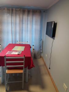 a dining room with a red table and a tv at Cabañas Rivadavia Spa in Vicuña