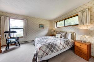a bedroom with a bed and a chair and a window at The Eagle's Nest in Lincoln City