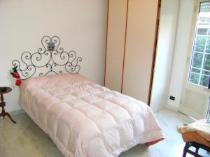 a bedroom with a white bed with a metal headboard at La Casina in Marina di Massa