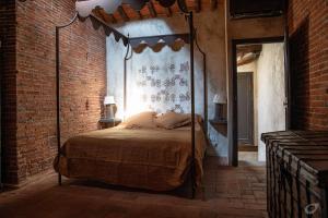 a bedroom with a canopy bed in a brick wall at Casa del Campanaro centro storico di Lucca dentro le mura in Lucca