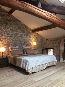 UzerにあるFort de la Bastideの石壁のベッドルーム1室(大型ベッド1台付)
