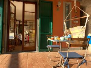 a porch with a hammock and a table and chair at Villa Vigna in Montignoso