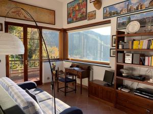 a living room with a desk and a chair and windows at Villa Vigna in Montignoso