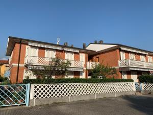 een bakstenen gebouw met een wit hek ervoor bij Casa Matilde in Massa