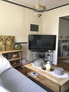 a living room with a couch and a table with a tv at Maison *** 400m plage du sillon et thermes marins in Saint Malo