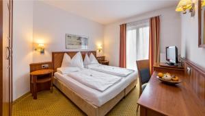 una camera d'albergo con un letto e una televisione di Hotel Millanderhof a Bressanone Altre 37 foto