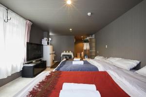 1 dormitorio con 1 cama grande y TV en Akabane TK Building 103, en Tokio