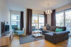 a living room with a couch and a tv at Apartamenty Tulip - visitopl in Międzyzdroje