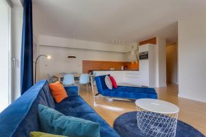 a living room with a blue couch and a table at Apartamenty Tulip - visitopl in Międzyzdroje