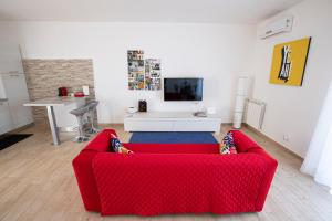 sala de estar con sofá rojo y TV en Valmontone Travel House, en Valmontone