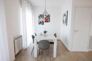 a white dining room with a white table and chairs at Valmontone Travel House in Valmontone